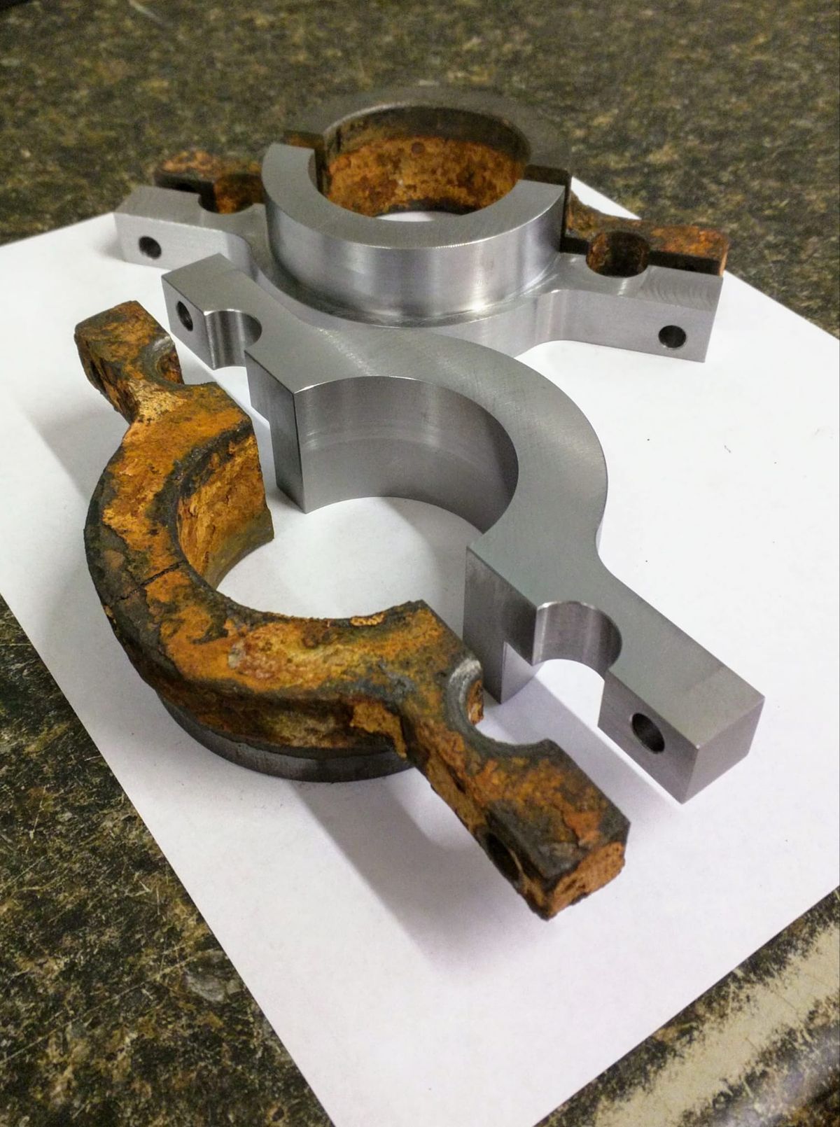 Worn original part next to its new machined replacement