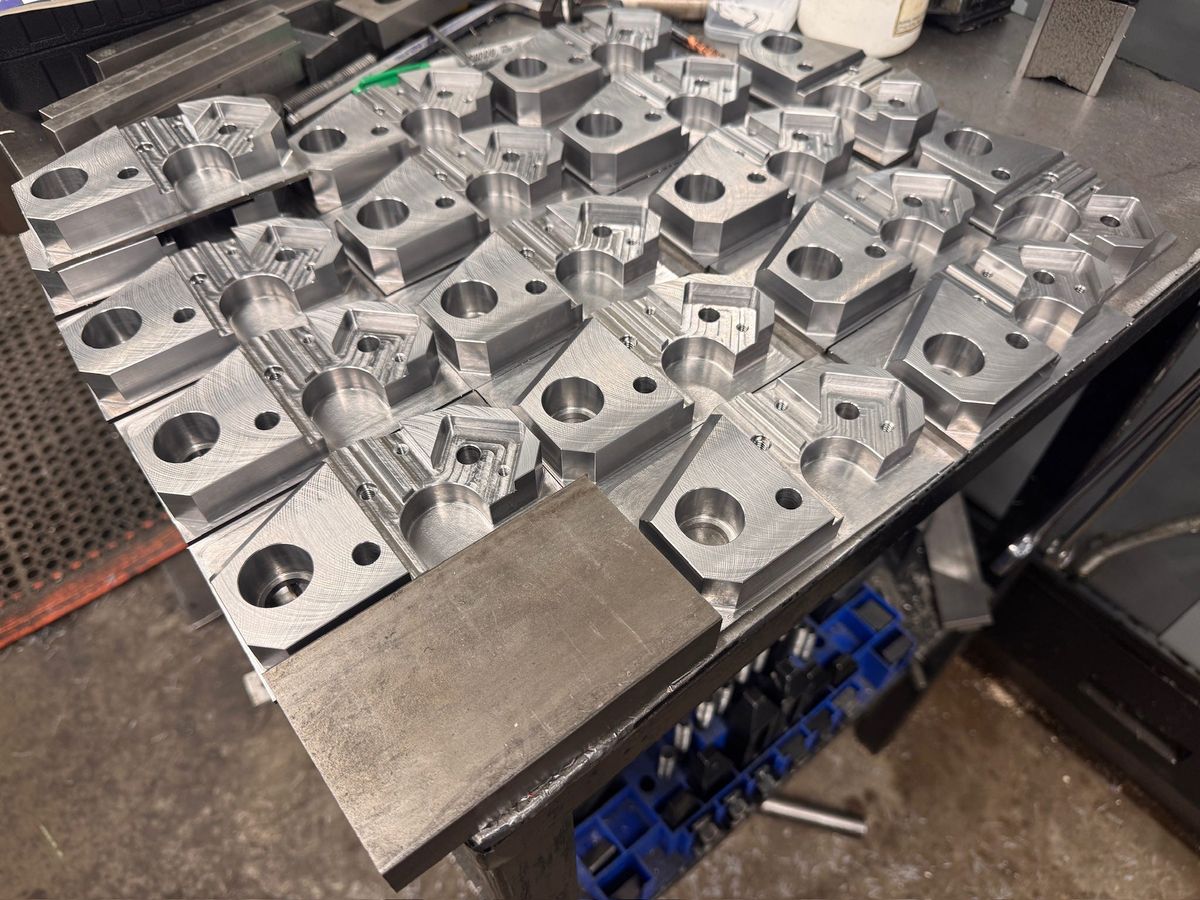 A table of identical CNC-milled aluminum blocks