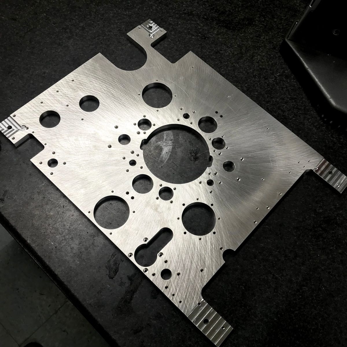Machined plate with a pattern of holes and slots